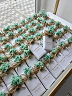 White boxes with greenery and twine on a decorative surface