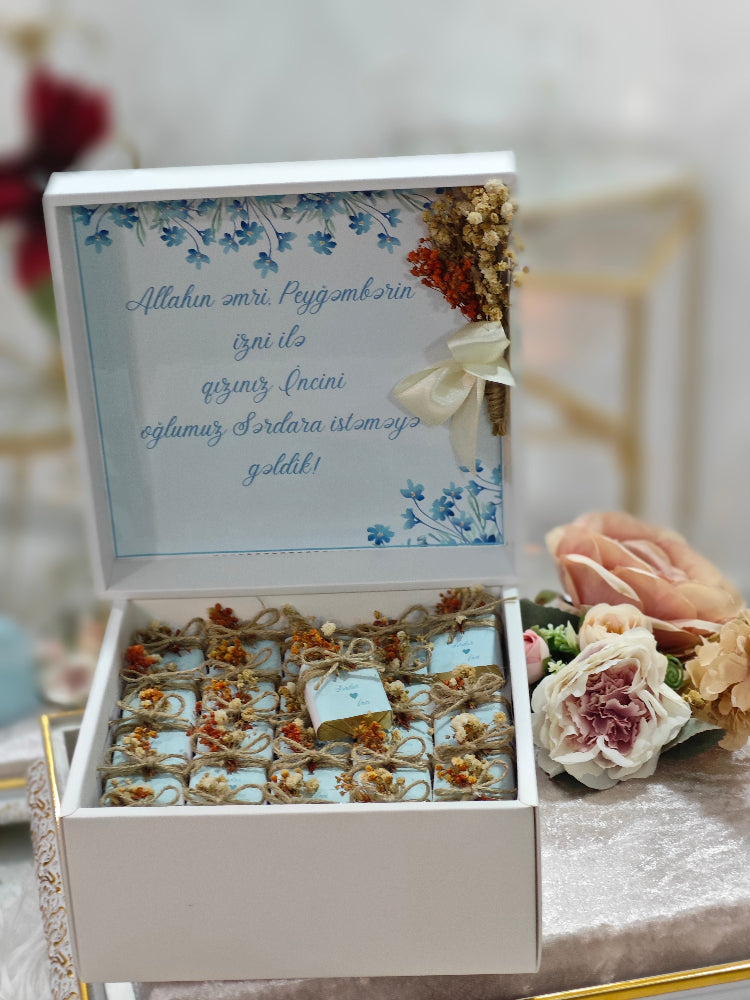 Decorative gift box with flowers and a message on a table