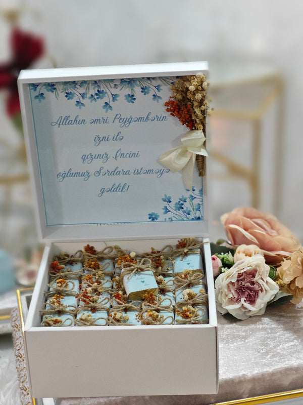Decorative gift box with flowers and a message on a table