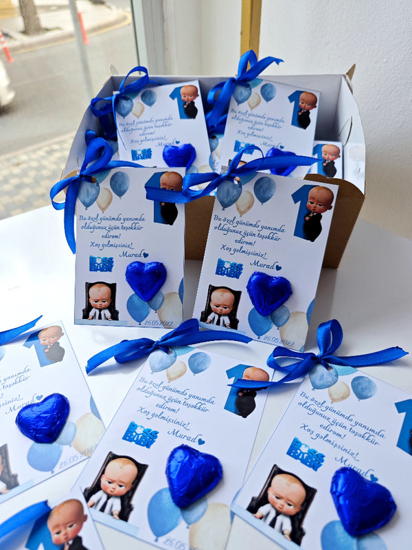Gift boxes with blue ribbons and heart-shaped blue candies on a white surface.