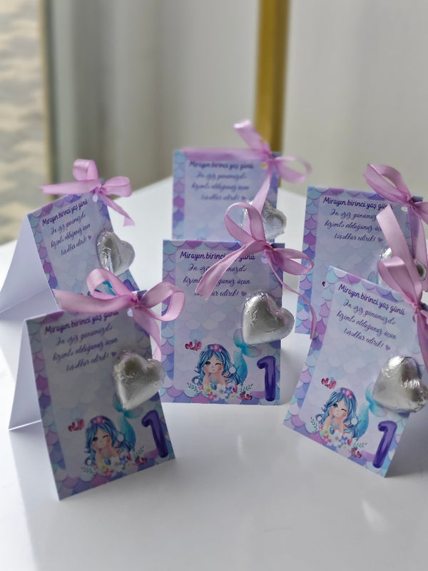 Decorative cards with ribbons and heart-shaped decorations on a white surface.