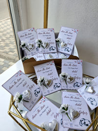 Collection of 'Save the Date' cards with floral designs on a decorative stand.