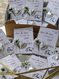 Wedding invitation cards with heart designs and 'Save The Date' text on a reflective surface.