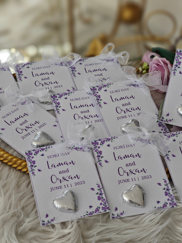 Silver heart-shaped earrings on display cards with a blurred background