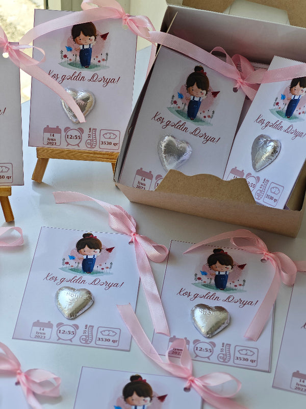 Heart-shaped earrings with pink ribbons and decorative cards on a white background