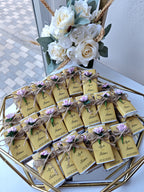 Decorative table setting with name tags and floral arrangement on a gold tray.