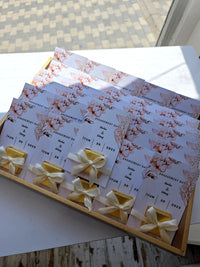 Set of floral wedding invitations with ribbons on a white surface