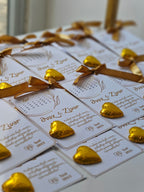 White cards with gold text and decorative elements on a white surface.