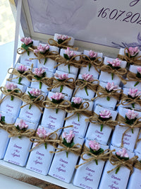 Set of small chocolates with floral decorations and labels, tied together with twine.
