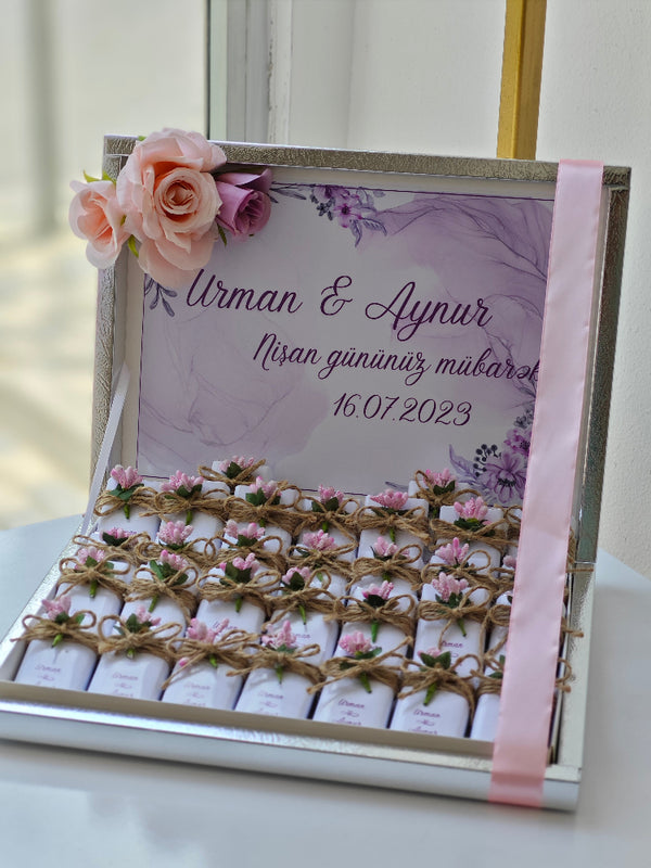 Decorative box with flowers and personalized text on a white surface