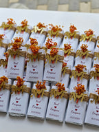 Small wrapped gifts with decorative bows on a white surface