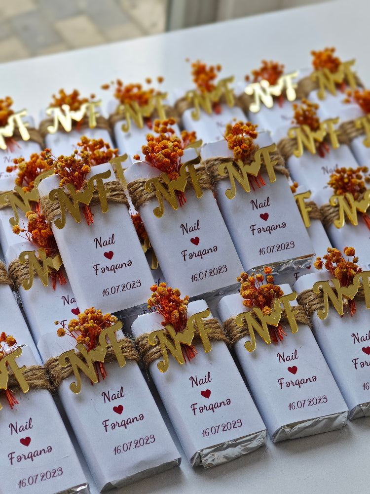 Decorative chocolate bars with personalized tags on a white surface
