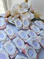 Decorative soap bars with decorative labels and a large flower arrangement in the background.