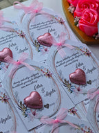 Heart-shaped chocolate candies on floral cards with pink ribbons, surrounded by pink roses.