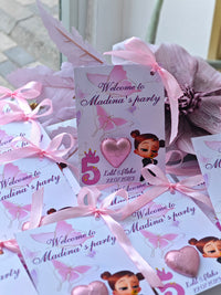 Party invitations with pink ribbons and butterfly designs, featuring a character and text.