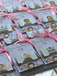 Baby shower favor bags with lion designs and pink ribbons on a white background