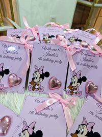 Invitations for a birthday party with Minnie Mouse design and pink ribbons.