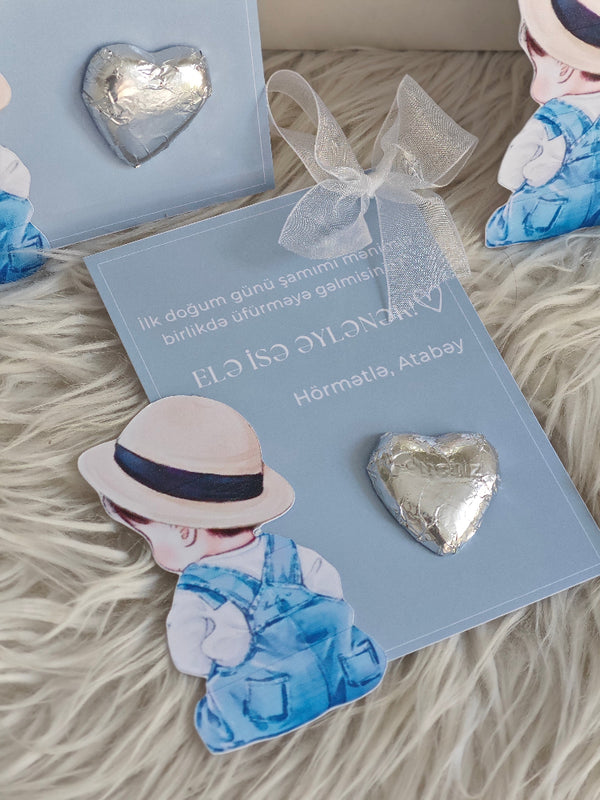 Heart-shaped earrings on a blue card with a decorative bow, placed on a textured surface.
