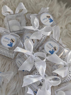 Small decorative boxes with white ribbons on a textured surface