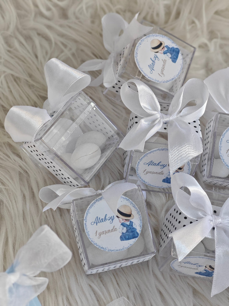 Small boxes with white ribbons on a textured surface