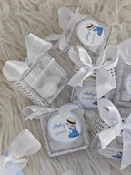 Small boxes with white ribbons on a textured surface