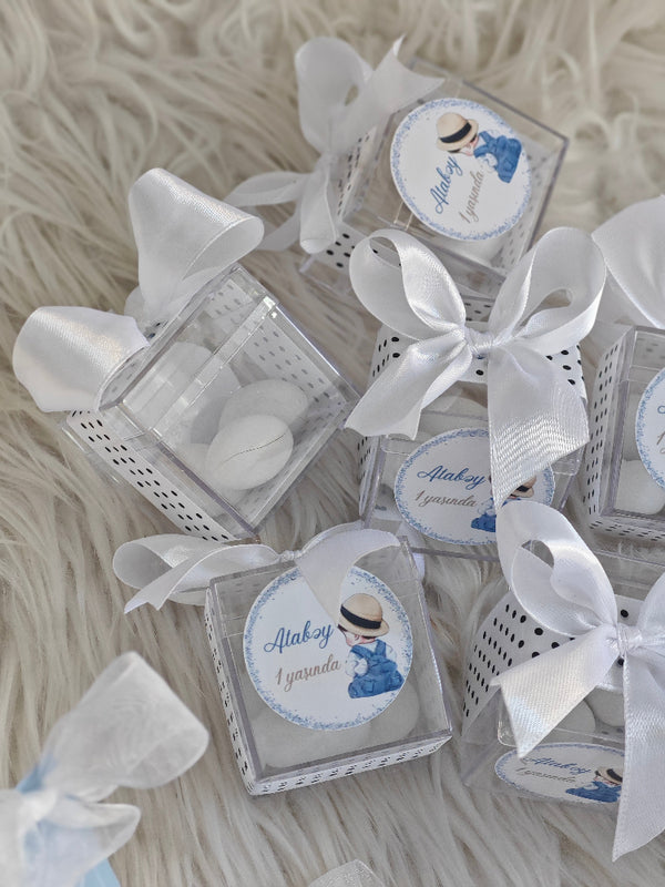 Small boxes with white ribbons on a textured surface