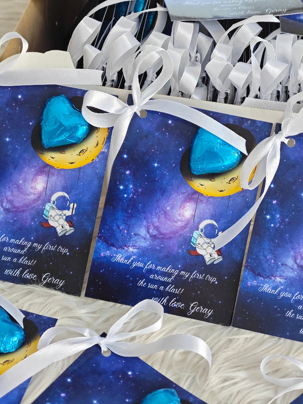 Greeting cards with space-themed design and blue heart-shaped objects, tied with white ribbons.