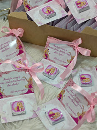 Collection of birthday party invitations with pink ribbons and princess design on a textured surface.