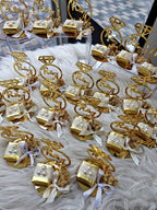 Gold jewelry display with 'Raj' branding on a white surface
