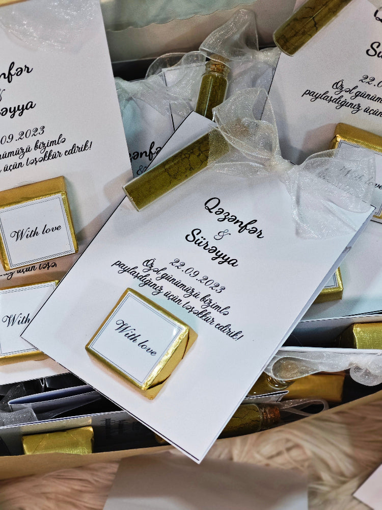White cards with gold accents and text, likely wedding invitations or similar documents.
