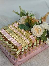 Bouquet of flowers with pink and gold ribbons on a white surface