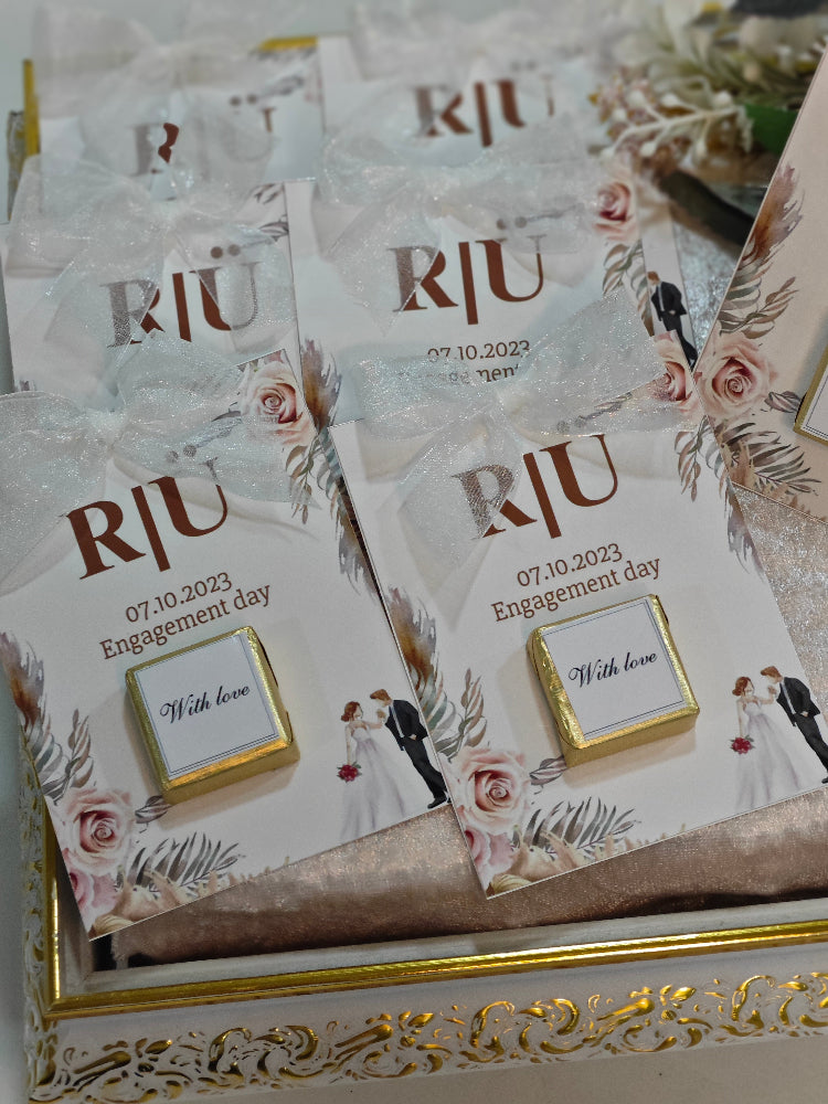 Set of wedding invitations with 'RJU' and floral designs on a decorative box.