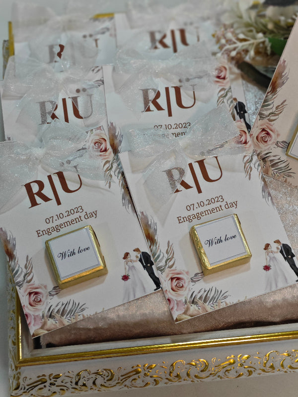 Set of wedding invitations with 'RJU' and floral designs on a decorative box.
