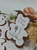 Baby shower invitation card with teddy bear design and text 'Happy 40 Days baby Mikael' on a floral background.