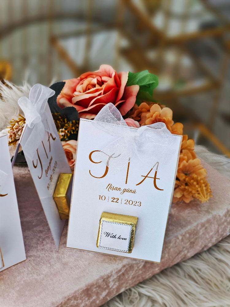 Decorative card with 'TIA' and a date, surrounded by flowers and gold elements.