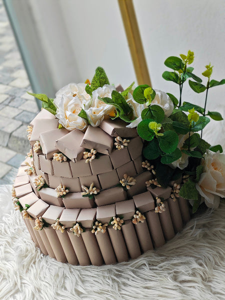 Three-tiered cake with floral decorations on a textured surface