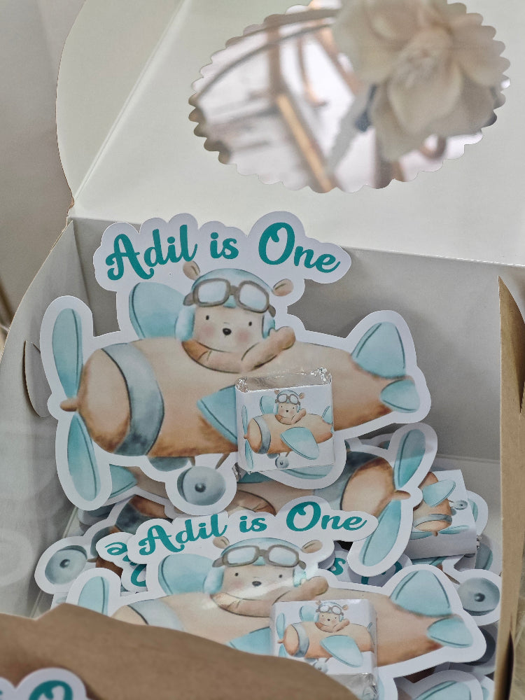 Decorative birthday card with airplane design and 'Adil is One' text.