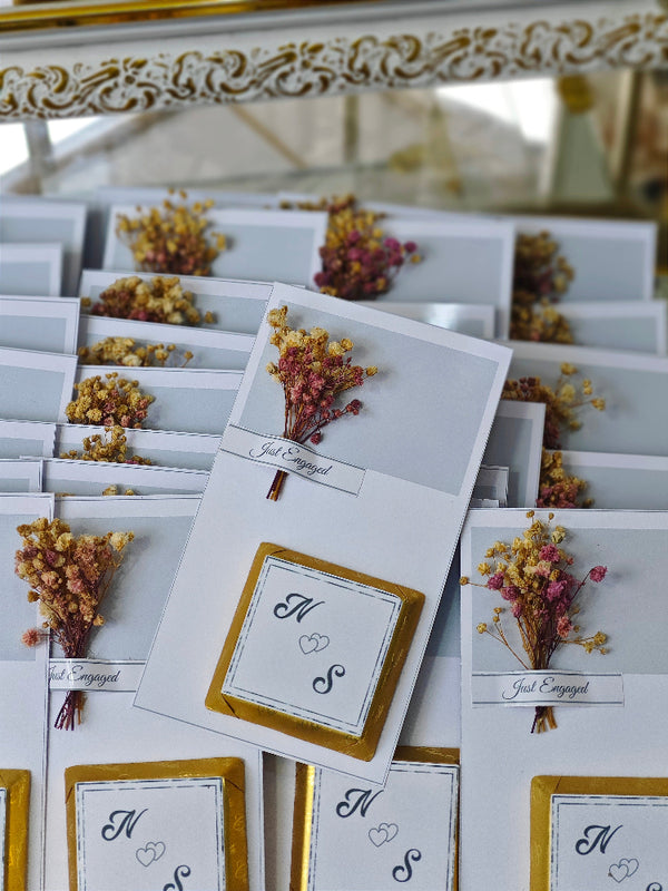 Engagement party place cards with floral decorations and 'Just Engaged' text.