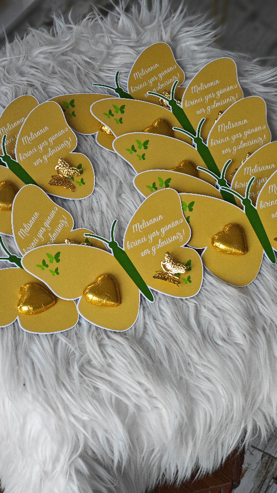 Decorative wreath made of gold heart-shaped cards on a fluffy white surface