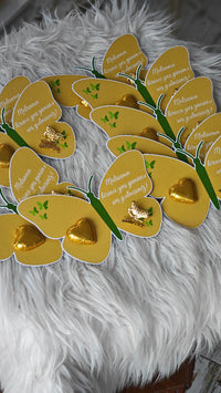 Decorative wreath made of gold heart-shaped cards on a fluffy white surface