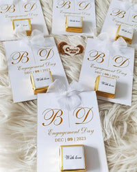 Engagement-themed gift boxes with personalized text on a soft, neutral background