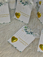 Set of cards with gold heart decorations and floral designs on a wooden surface