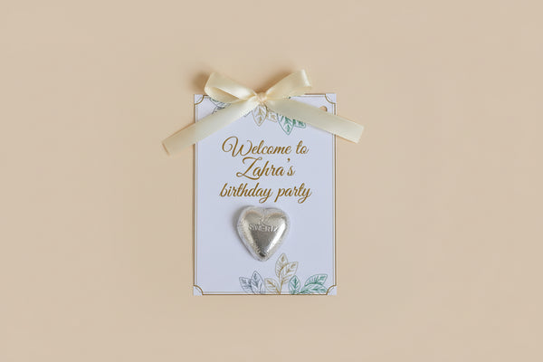 Decorative birthday party invitations with heart-shaped decorations and flowers on a textured surface.
