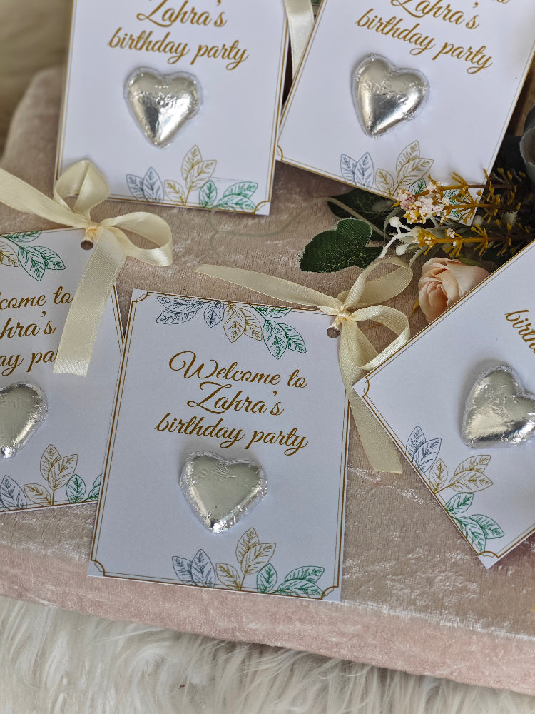 Invitations for Zahra's birthday party with heart-shaped decorations on a textured surface.