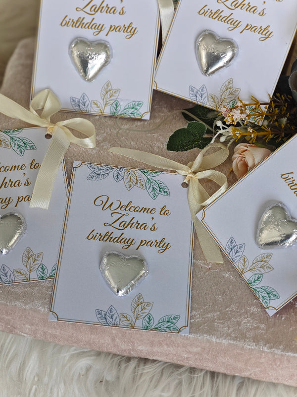 Invitations for Zahra's birthday party with heart-shaped decorations on a textured surface.