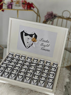 Wooden box with tuxedo designs and a card inside, on a soft surface.