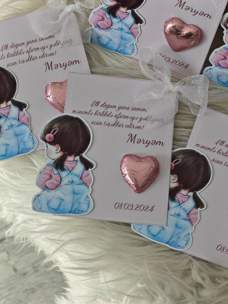 Heart-shaped earrings on a card with decorative elements on a textured surface