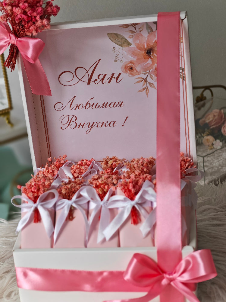 Decorative gift box with pink ribbons and flowers, featuring Russian text.