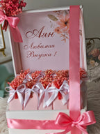 Decorative gift box with pink ribbons and flowers, featuring Russian text.