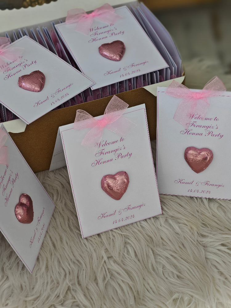 Heart-shaped favors with personalized cards on a textured surface